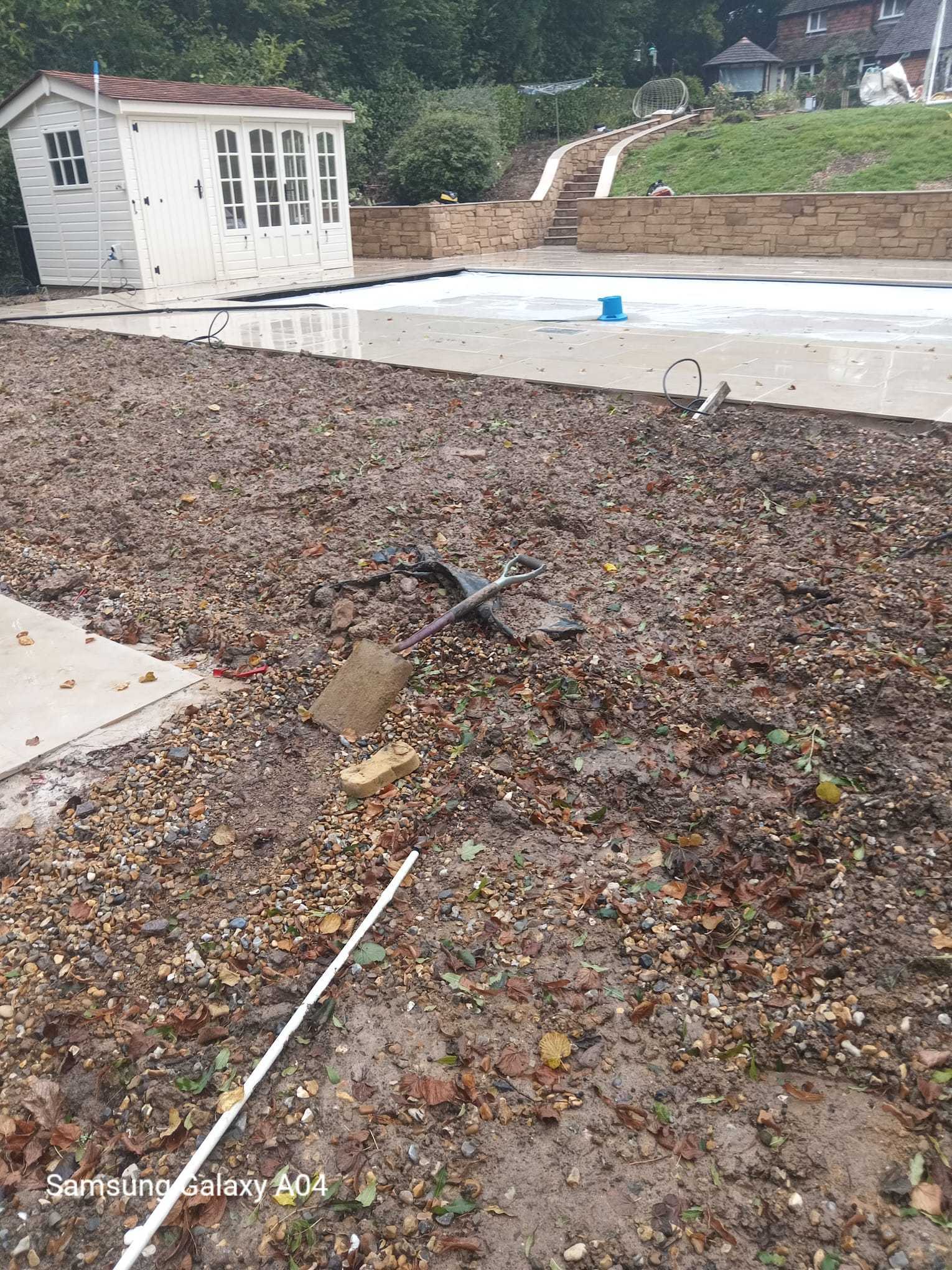 Garden transformation — ground levelled and prepared beside a new patio and summer house