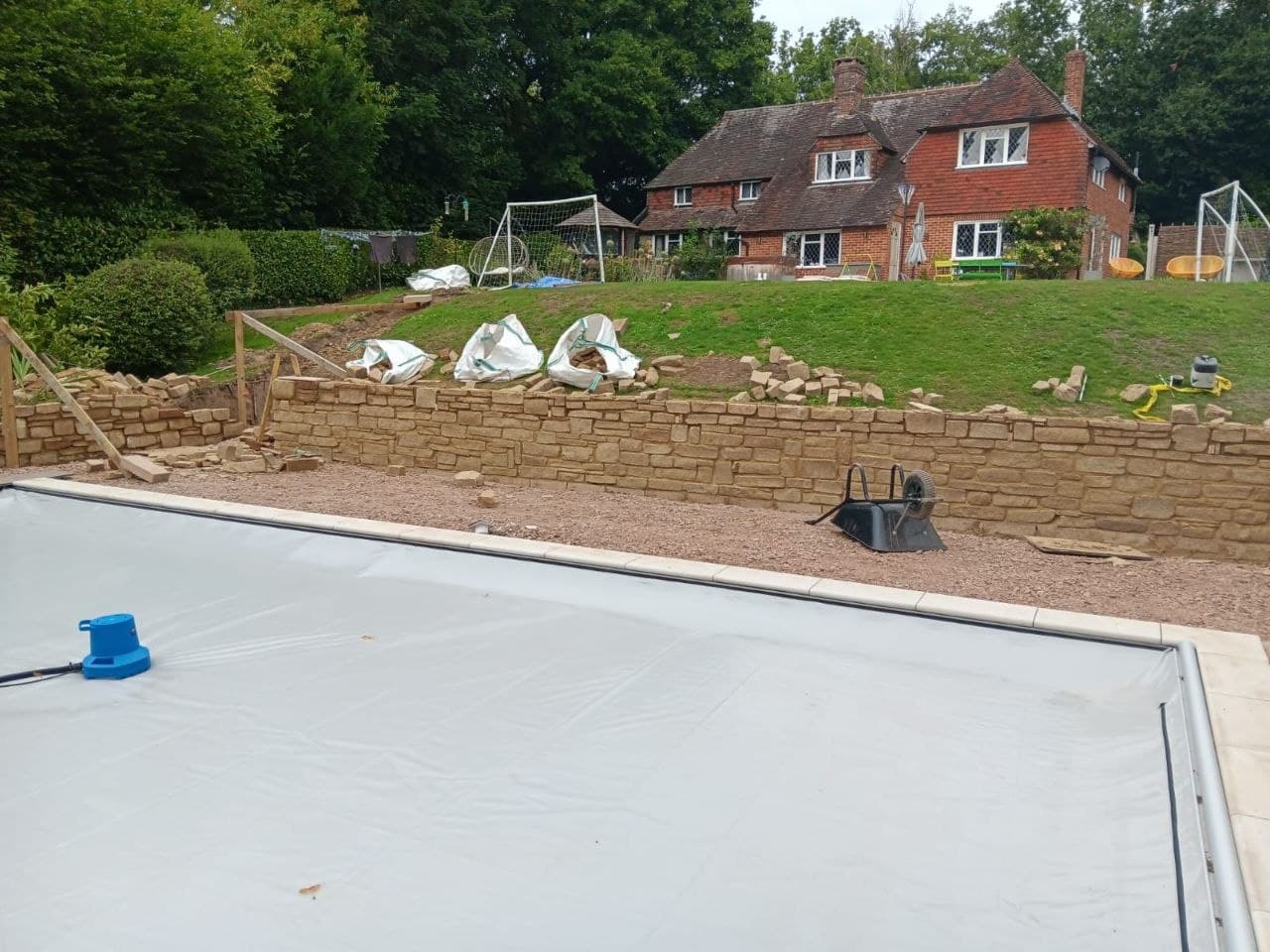 Sandstone paved side-access path running between a hedge and the house