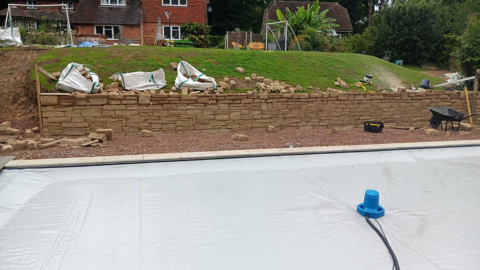 Natural stone retaining wall built across a sloping garden